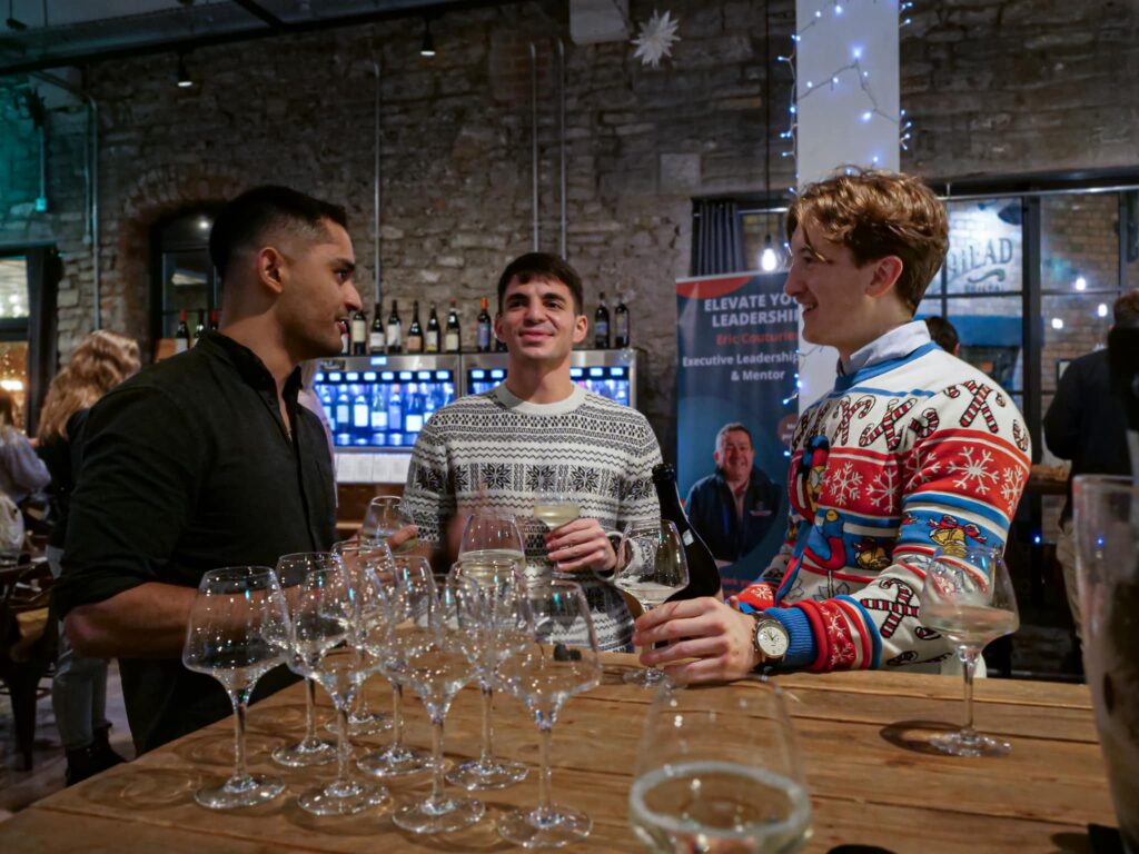 A group of 3 young men talking around the table at a networking event